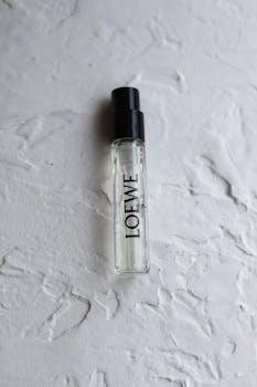 Loewe perfume sample bottle on textured surface, showcasing elegant packaging design.